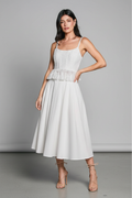 Close-up – collarbone to mid-thigh, hand on peplum