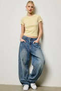 Leaning against wall, hands in pockets