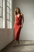 Legs crossed, leaning on wall, smoldering gaze