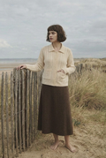 Morrow Coast Cardigan beside coastal fence